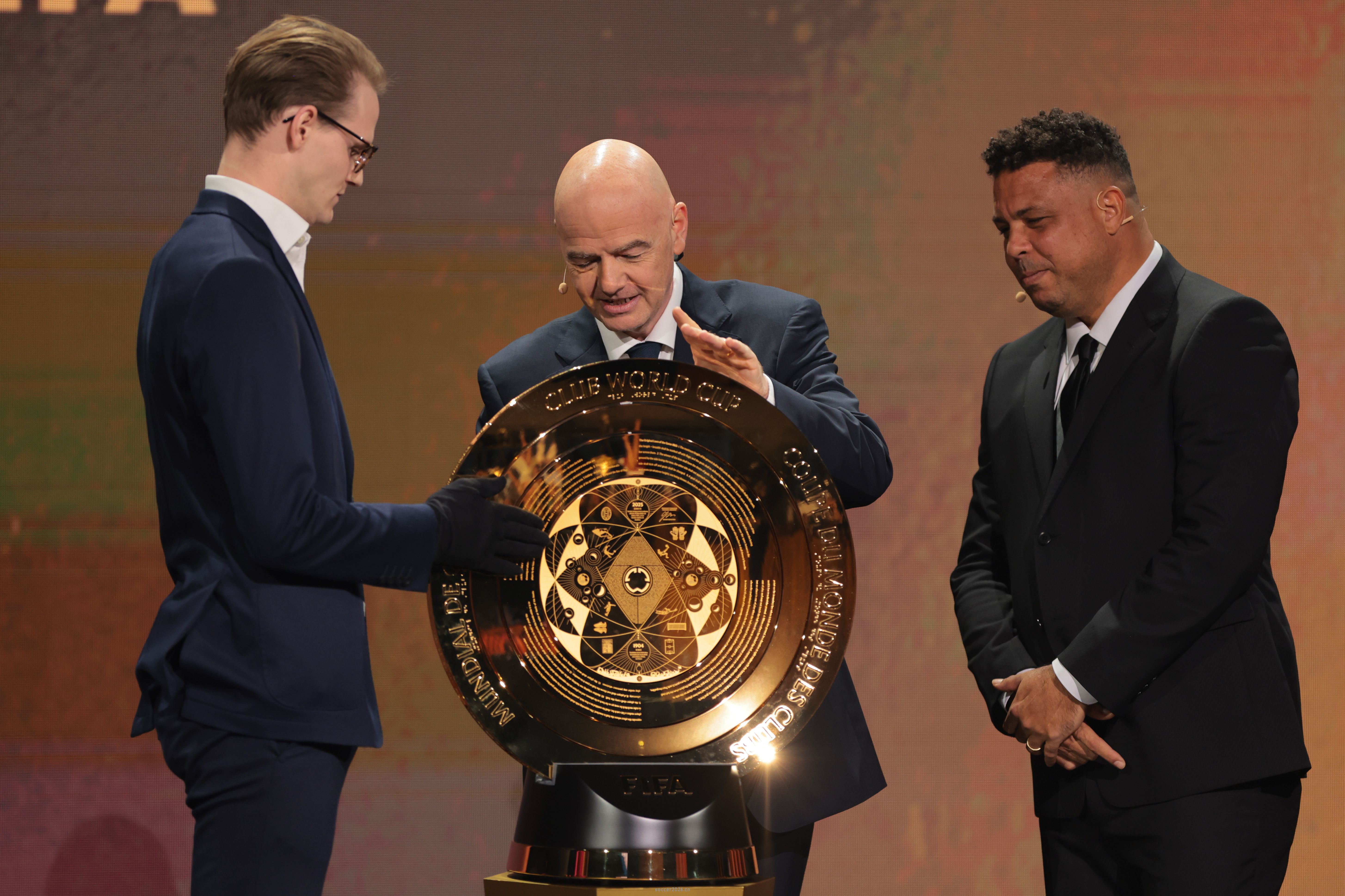 Dec 5, 2024; Miami, FL, USA; FIFA president Gianni Infantino (center) and Brazilian former soccer player Ronaldo Nazario present the FIFA Club World Cup trophy during the Club Word Cup draw at Telemundo Studios. Mandatory Credit: Sam Navarro-Imagn Images