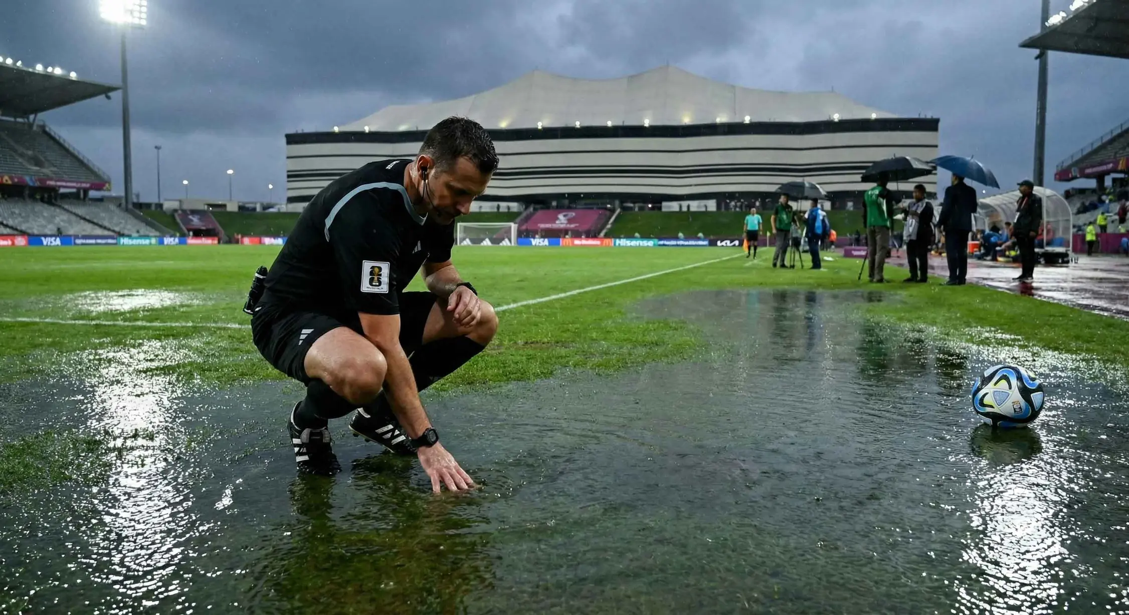 裁判检查球场积水情况以决定是否延期世界杯比赛
